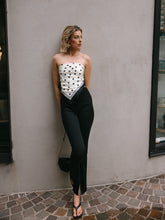 A lady wears a scarf and skinny jeans.